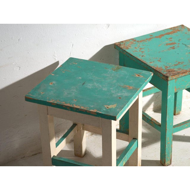 A pair of antique bedside tables in pine wood, with a square top and four tapered legs tied by box stretchers. They...
