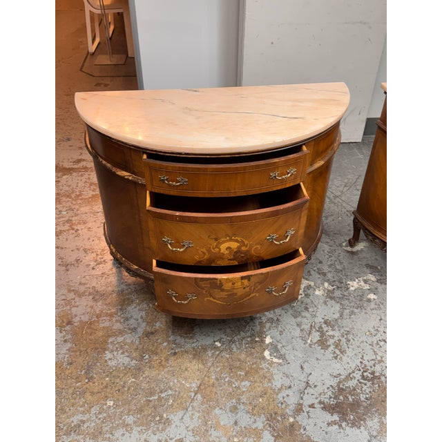 Design Plus Gallery presents a Neoclassical Semicircular Demi-Lune Commode. The commode has a shaped marble top above a...