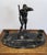 A dramatic early 20th century Austrian Art Deco bronze Inkwell of a muscular male holding a scythe with one arm and wiping...