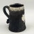 An early 20th Century leather tankard with a sterling silver rim and presentation plaque on the front. The plaque reads to...