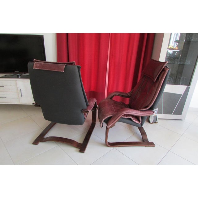 Relaxed leather armchairs, plum or wine color, sled base giving it flexibility and spring feel, handle to activate the...