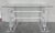 An impressively Lucite console in the manner of Karl Springer with glass top. It has two lyre pedestal flanked by two...