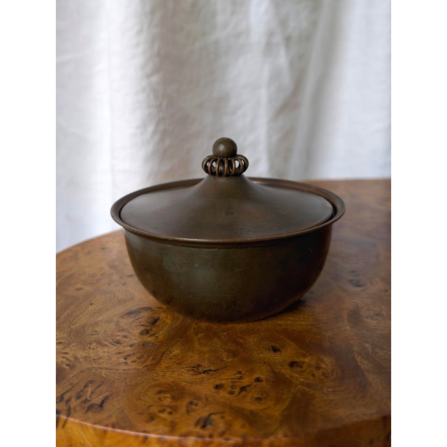 A 1930s vintage just andersen bronze art deco pot featuring a modernist style hand carved decorative lid, lipped rim and...