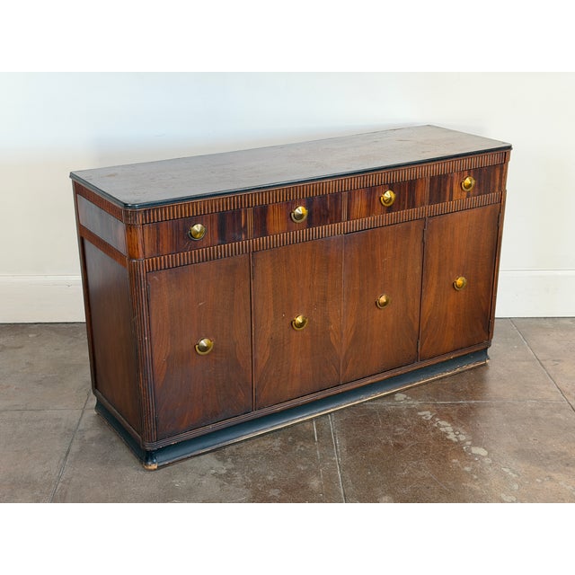 1940's walnut and brass credenza in vintage condition. Discoloration on the top and patinated wood all around. Appears...