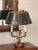 French bouillotte lamp with a dark green tole shade bordered in gilt palmettes, tulips and scrolling vines. The shade...