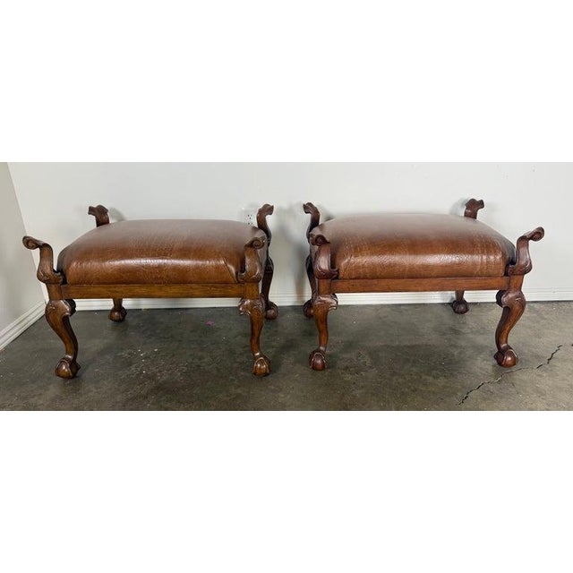 This handsome pair of upholstered benches features richly carved wooden frames paired with warm, embossed leather seats,...
