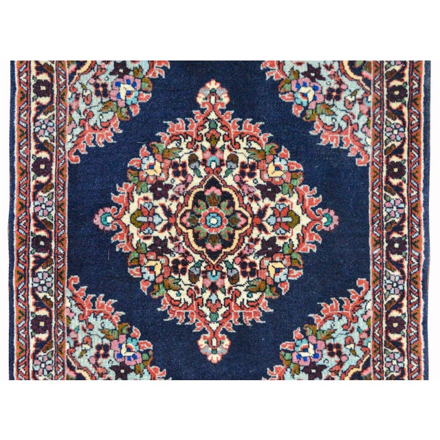 A wonderful vintage Persian Bidjar rug with a diamond floral medallion woven in red, pink, green, yellow, and light indigo...