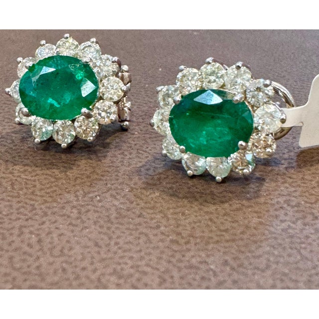 Approximately 6 Carat Oval Shape Natural Emerald & Diamond Post Back Earrings 14 Karat White Gold Two emerald weighing...