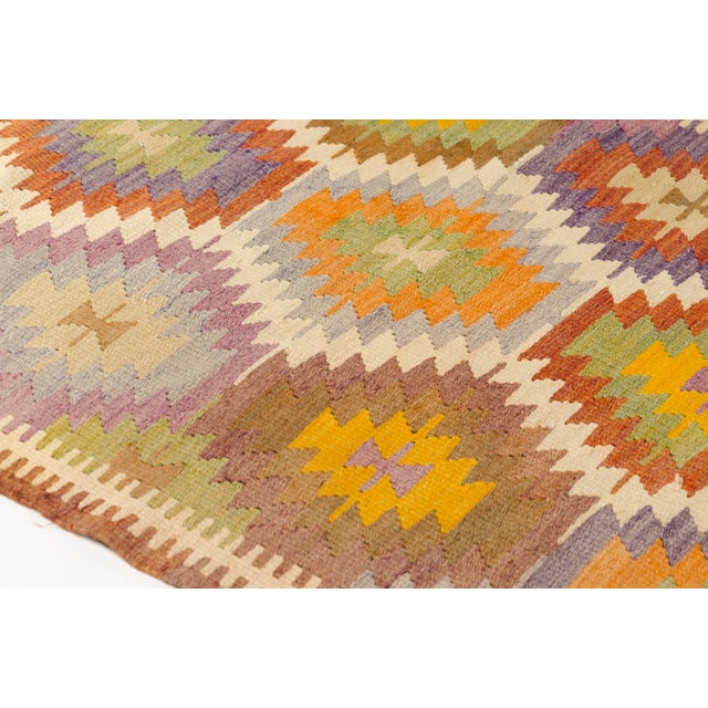 This is a vintage Turkish Oushak rug from the Mid 20th Century. The piece was hand-knotted.