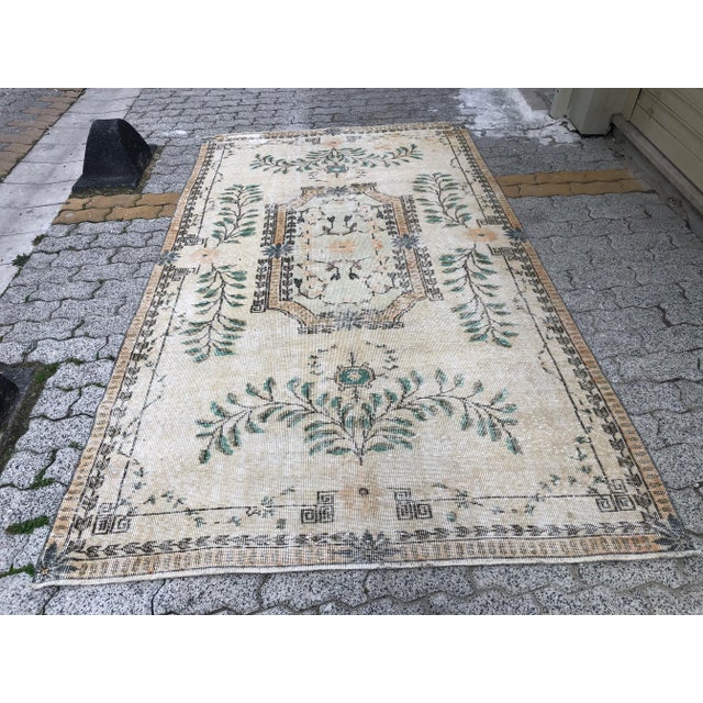 This is a vintage Turkish Oushak rug from the 1960s. The piece was hand-knotted.