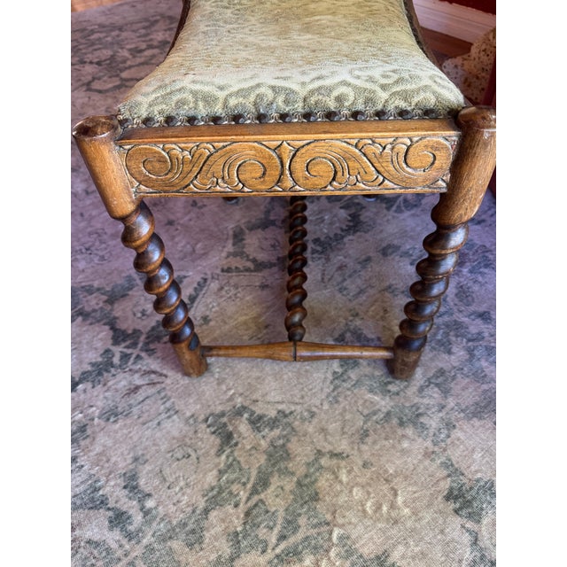 Antique footstool with barely twist legs and a carved wooden apron. I’ve read it’s from 1910 but I’m not sure. Could use...
