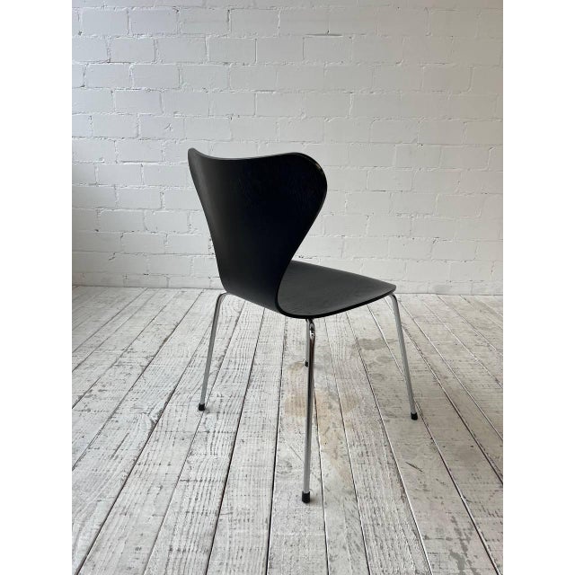 The classic 3107 chair by Arne Jacobsen for Fritz Hansen: frame made of chrome-plated tubular steel and a one-piece seat...