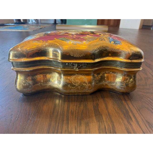 A large porcelain box with a beautiful gold and painted decoration.
