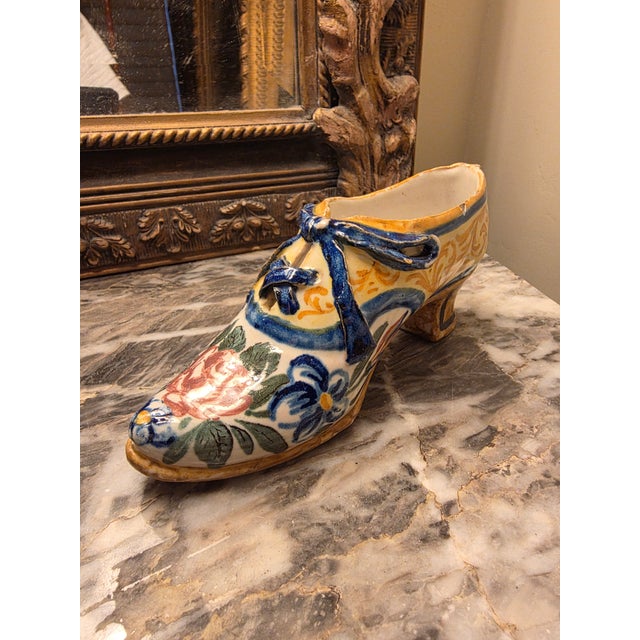Unusual antique shoe form with raised laces and hand paint decorated surfaces with heavy glaze.