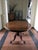 This magnificent and elegant tilt top oval table, has the top hand made in a selection of briar root and the central foot...
