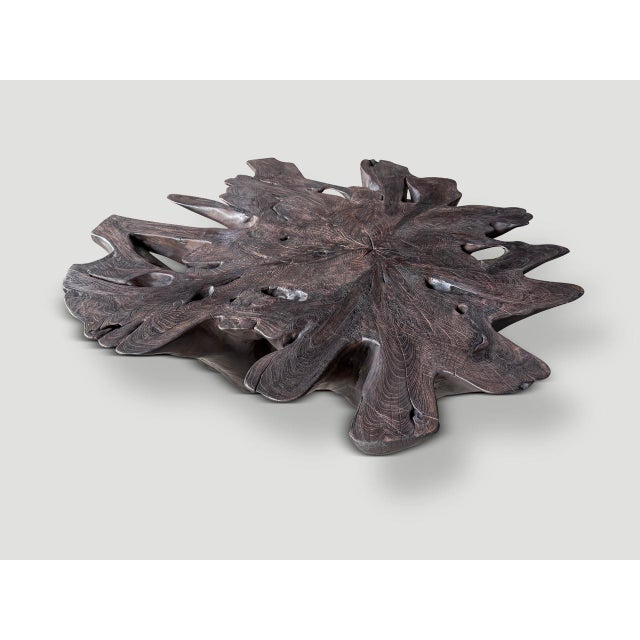 Impressive amorphous coffee table hand carved from a century old reclaimed teak root. A graduation from the bottom to the...