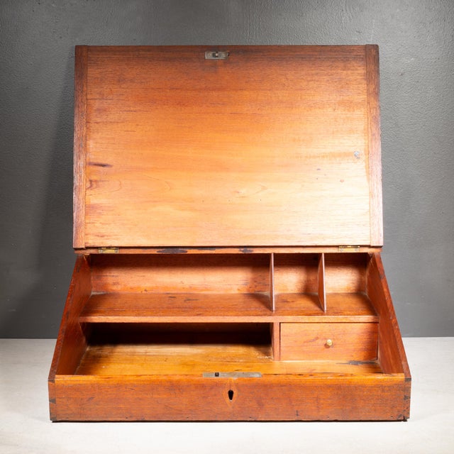 ABOUT An antique oak slanted shop keeper's table top desk with flip top, four cubbies and one drawer with brass handle....