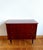 Vintage 1950s dark lacquered wood chest of drawers that opens into a dressing table. Features gold door knobs and gold-...