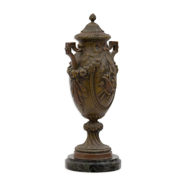 A refined mid-century Hollywood Regency–style bronze lidded urn, inspired by classical French design. This decorative...