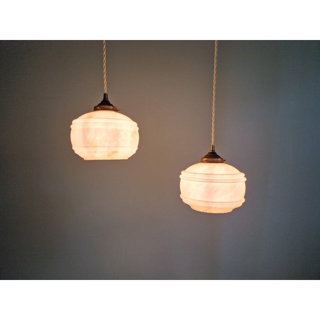 Pair of Art Deco pendant lights in pink marbled opaline glass, 1920s-30s. Each pendant light has been restored and...