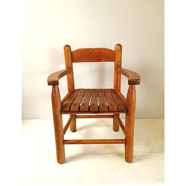 This vintage handmade child’s wood armchair features a beautifully contoured slat seat paired with thick, hand-turned...