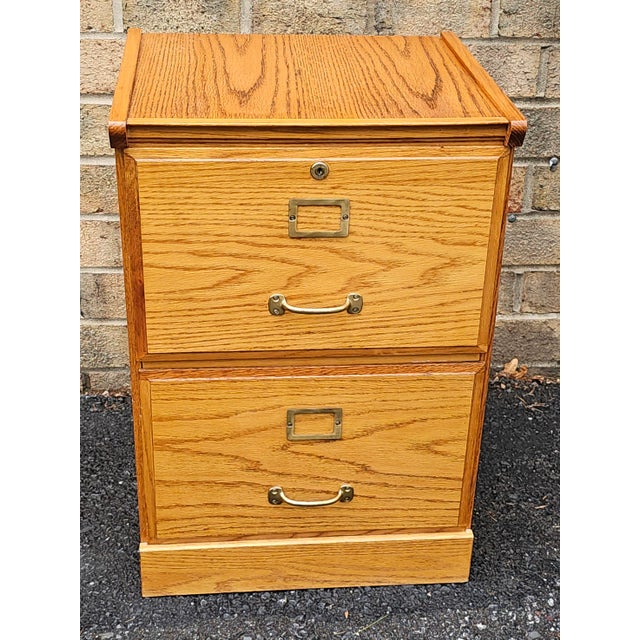 A Mid-Century Oak Two-Drawer Legal Size Filing Cabinet with lock. Will hold legal size and letter size file folders. Come...