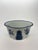 A vintage porcelain cachepot styled after Mottahedeh, with blue pineapple and leafy botanical decoration against a white...
