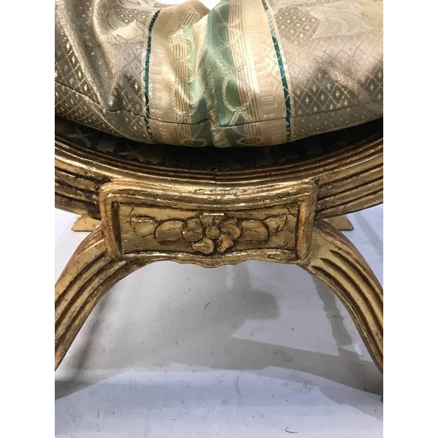 Gilt wood bench with hand-carved details. Having a matching pillow and tassels.