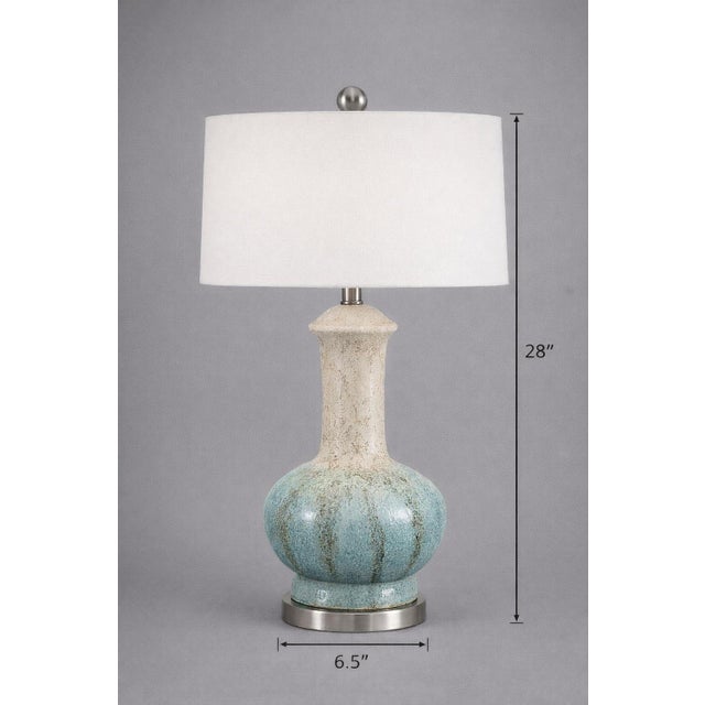 A sculptural late 20th century ceramic table lamp featuring a beautifully mottled reactive glaze that transitions from...