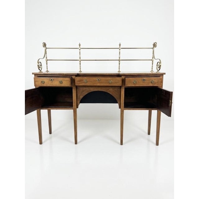 A fine 19th century mahogany sideboard of elegant inverted breakfront form, surmounted by a decorative brass gallery with...