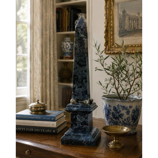 A beautifully proportioned marble obelisk in richly veined shades of blue and cream. The sculptural silhouette and...