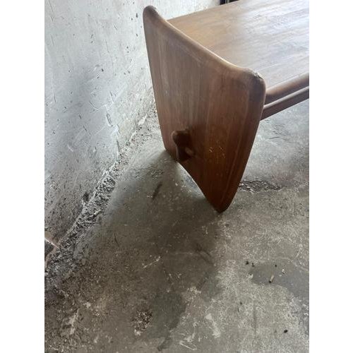 Introduction a characterful vintage wooden coffee table featuring softly rounded edges and sculptural side panels. The...