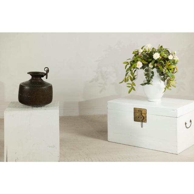 This vintage Indian hand-tooled metal milk jug has a strong decorative presence, with a rounded body, flared neck, rolled...