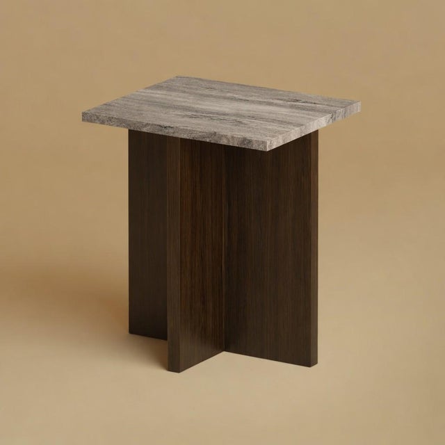 Titanium travertine over a base of solid oak gives the Tinos its balance. It is a small, low table scaled for the side of...