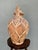 A large terracotta amphora encased in a precise hand-woven rattan lattice from shoulder to base. Organic tension of...