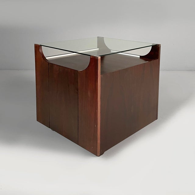 Cubobar bar cart with a glass top and wooden structure. The sides feature four compartments with drop-down doors and...