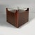 Cubobar bar cart with a glass top and wooden structure. The sides feature four compartments with drop-down doors and...