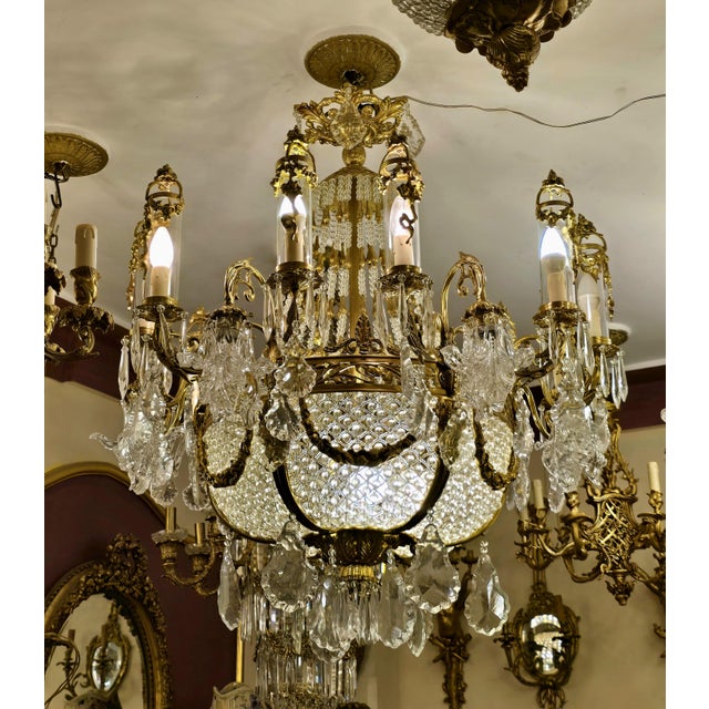 This distinctive chandelier features a rich dark gold finish that enhances its majestic presence. With intricately carved...