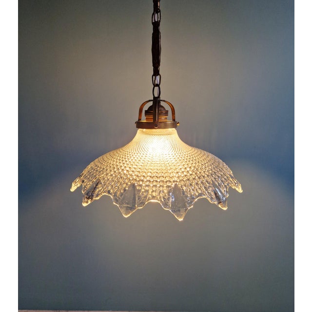 Art Deco pendant light in scalloped clear glass with a brass frame, 1920s-30s. The pendant light has been rewired and is...