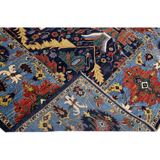 Beautiful antique Serapi-style hand-knotted wool rug with a navy blue color field. This piece has a light blue-designed...