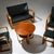 Seating ensemble comprising two armchairs, a two-seater sofa, a stool, and a side table. The pieces are upholstered in...