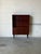 This striking storage unit features upper open shelves and a concealed lower compartment. Elevated on slender tapered...