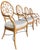 A stylish set of four rattan dining armchairs featuring distinctive circular medallion backs with radiating spoke detail...