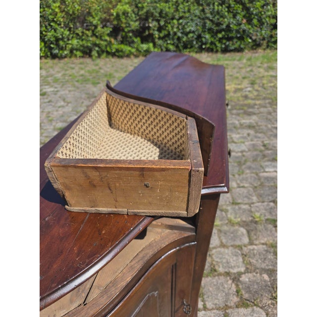 An elegant Venetian sideboard in solid walnut dating back to the first half of the 19th century. The piece features a...