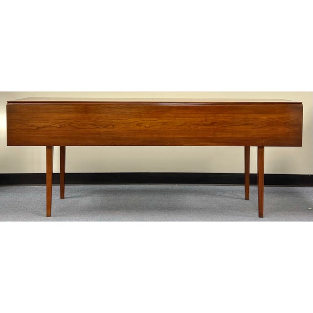 Solid American black cherry drop leaf harvest dining table made by Henkel Harris. Simple elegance with finely tapered legs...
