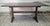 A Mid Century Early American Style Stained Oak Trestle Dining Table. Measures 68" in width, 35" in width and 29.5" in...