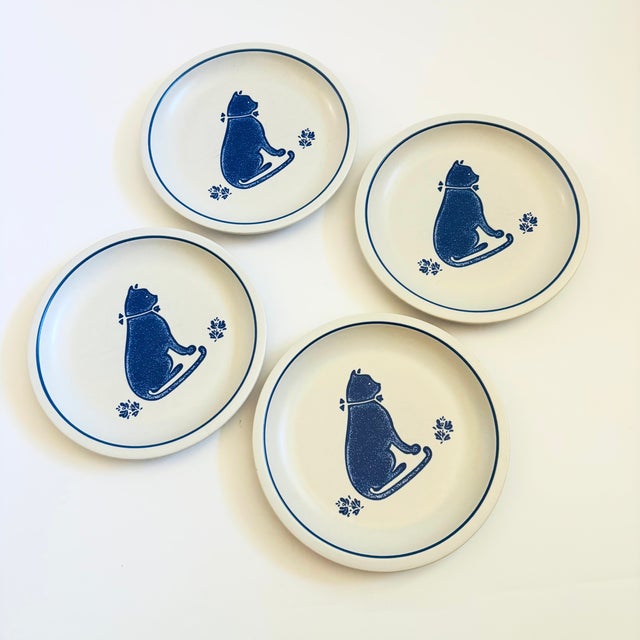 A set of 4 vintage Pfaltzgraff Yorktowne salad or desert plates. Blue and off-white glazes with a cat design in the...