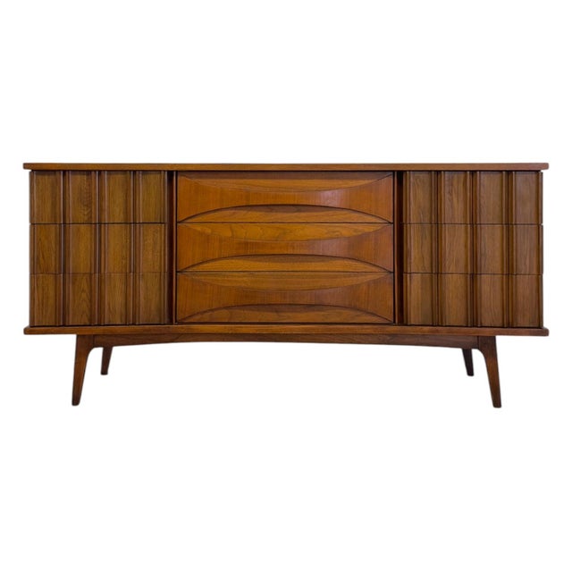 This vintage mid-century modern nine-drawer credenza is constructed from walnut and features a distinctive tri-sectional...