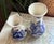 1980's Delft blue and white vase pair decorated in a floral design. Rounded with flared opening. Marked Delft with artist...