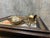 A framed assemblage of vintage objects, mounted on a crocheted lace ground inside a richly ornamented wood frame. The...